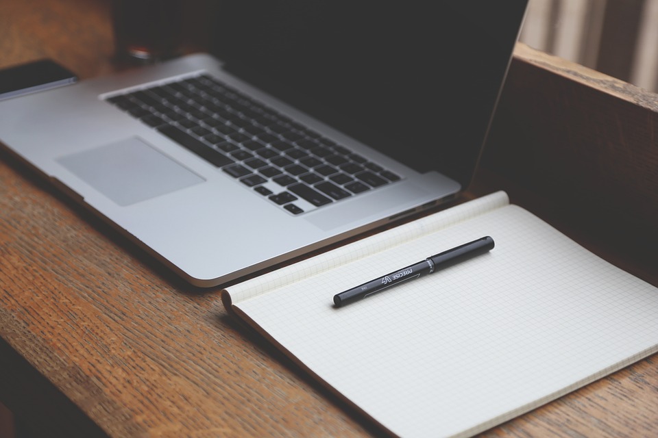 Image of a laptop computer and a notebook