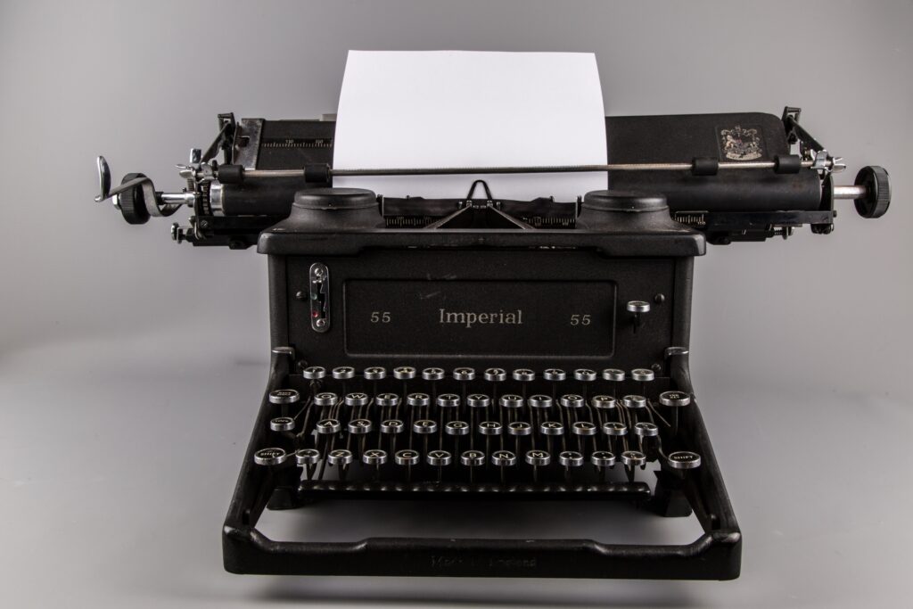 Image of a black typewriter with blank paper