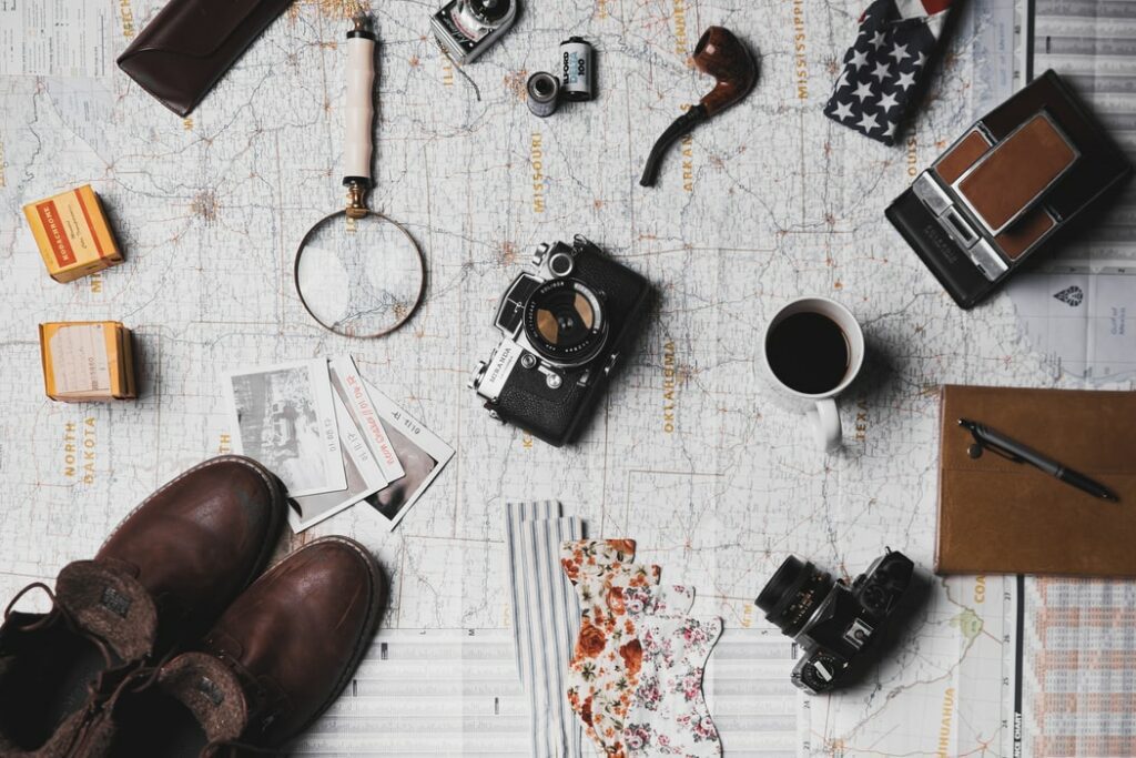picture of a magnifying glass, camera, and other gear on a map